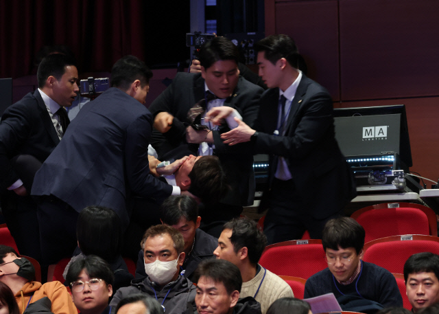 강성희 진보당 의원이 지난 18일 전라북도 전주시 덕진구 한국소리문화의전당 모악당에서 열린 전북특별자치도 출범식에서 윤석열 대통령이 입장하며 참석자들과 악수하는 동안 경호원들에게 제지당해 끌려나가고 있다. <연합뉴스>